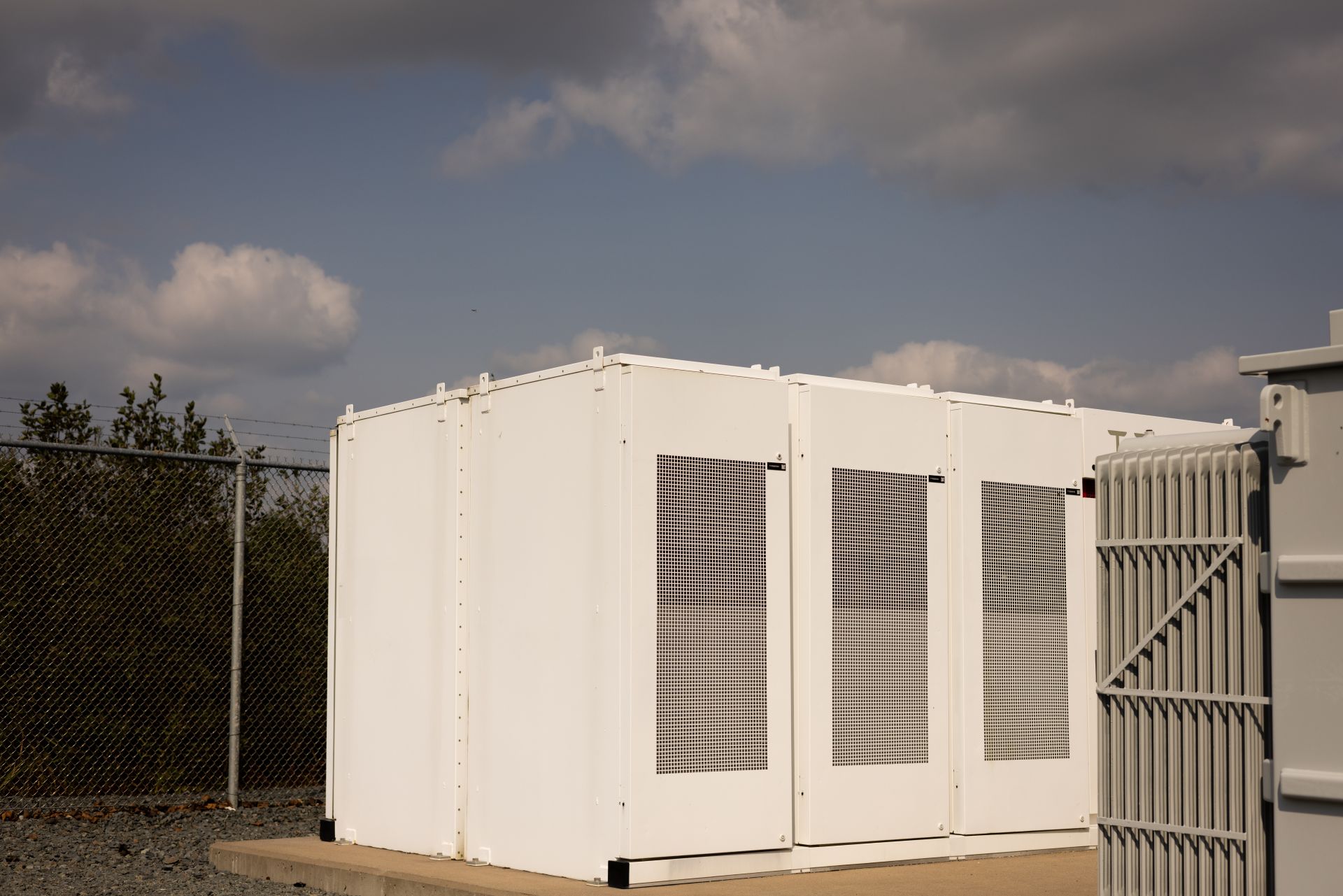 A white coloured battery storage facility surrounded by fences
